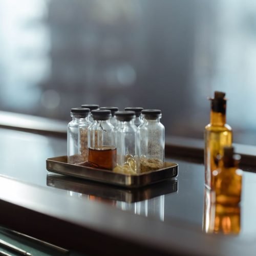 A captivating arrangement of medicine bottles on a reflective surface, evoking a sense of chemistry and alchemy.